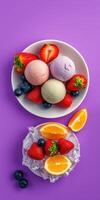 Colorful ice cream bowls with fresh fruits placed on a vibrant purple background photo
