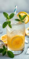 Refreshing citrus lemonade with mint served in a tall glass garnished with lemon slices and mint leaves on a light background photo