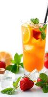Refreshing fruit drink garnished with mint and strawberries served with ice and citrus slices in a bright setting photo