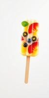 Colorful fruit popsicle with assorted berries and mint leaf on a stick enjoyed in warm weather photo