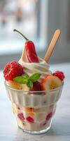 Delicious dessert featuring soft-serve ice cream topped with fresh fruits and a chili pepper in a stylish glass dish photo
