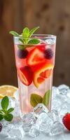 Refreshing summer drink with colorful fruits and mint served over ice in a tall glass photo
