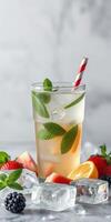 Refreshing summer beverage with mint and assorted fruits served with a striped straw photo