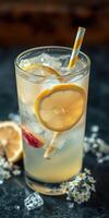 Refreshing lemon beverage served in a tall glass with ice and colorful straw on a dark background photo