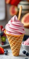 Soft serve ice cream cone with pink swirl and wooden stick on a table filled with fresh fruits and dessert bowls photo