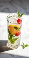 Refreshing citrus drink with raspberries and mint on a sunny marble surface photo