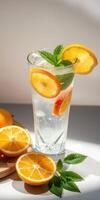 Refreshing citrus drink with slices of lemon and mint leaves in a clear glass on a bright surface photo