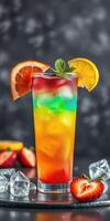 Colorful layered drink with fresh fruit garnishes served on a dark surface photo