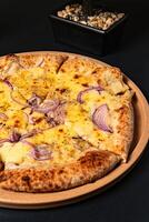 a pizza with onions and onions on it sits on a table. photo
