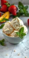 Creamy vanilla ice cream served in a bowl with fresh mint leaves and ripe strawberries on a marble countertop photo