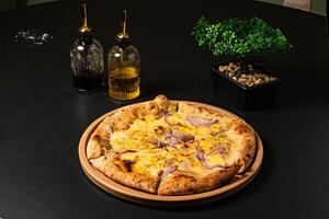 a pizza with onions and onions on it sits on a table. photo
