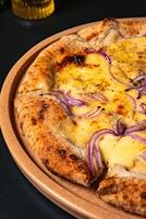 a pizza with onions and onions on it sits on a table. photo