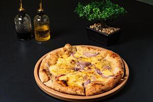 a pizza with onions and onions on it sits on a table. photo