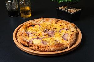 a pizza with onions and onions on it sits on a table. photo