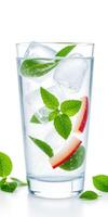 Refreshing beverage with ice cubes, mint leaves, and apple slices in a tall glass on a white background photo