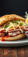 Delicious sandwich filled with sliced meats and fresh vegetables on a wooden table photo