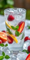 Refreshing summer drink with mint, citrus, and berries served in a tall glass with ice photo