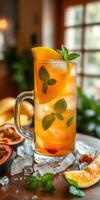 Refreshing beverage with tropical fruits and mint served in a clear glass on a wooden table photo