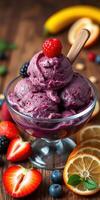 Purple berry ice cream served in a glass bowl with fresh fruit on a wooden table photo