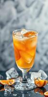 Refreshing orange drink served in a tall glass with ice and garnished with citrus slices photo