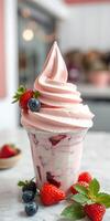 Decadent strawberry and berry swirl ice cream served in a clear glass cup with fresh fruit garnish photo