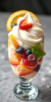 Colorful fruit parfait with creamy topping and fresh berries served in a glass dish photo