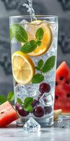 Refreshing summer drink with fresh fruits and mint in a clear glass photo