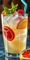Refreshing summer cocktail with citrus slices and mint leaves served in a tall glass photo