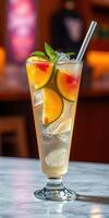 Refreshing fruit cocktail served in a tall glass filled with ice and garnished with mint and sliced peaches photo