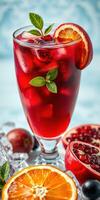 Refreshing red drink garnished with mint and citrus, surrounded by fresh fruits on ice photo