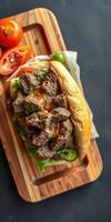 Savory beef sandwich with fresh vegetables served on a wooden board at a casual dining setting photo