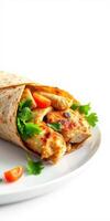 Delicious chicken wrap with fresh vegetables and herbs served on a white plate for a healthy meal option photo