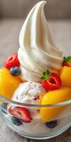Delicious dessert featuring creamy soft-serve ice cream topped with fresh fruits served in a clear glass bowl photo