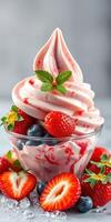 Delicious strawberry and blueberry dessert served in a glass bowl with a sprig of mint photo