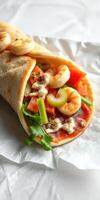 Fresh shrimp wrap with vibrant vegetables and creamy sauce served on a soft tortilla photo