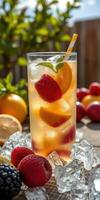Refreshing summer beverage with strawberries and citrus fruits garnished with mint beside fresh fruit on a sunny day photo