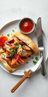 Grilled chicken sandwich with fresh vegetables and dipping sauce served on a white plate photo