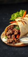 Delicious taco wrap filled with seasoned meat, fresh vegetables, and a side of creamy sauce on a wooden plate photo