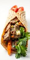Delicious beef wrap filled with fresh vegetables and herbs served on a plain background photo