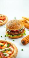 Delicious freshly prepared burger with fries and mini pizzas on a clean white table photo