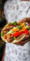 Freshly prepared taco with grilled chicken and colorful vegetables in a casual setting photo