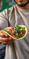 Homemade taco filled with grilled chicken, fresh vegetables, and cilantro during a sunny outdoor gathering photo