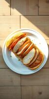 Sliced roasted chicken served on a white plate with green garnish and wooden background photo