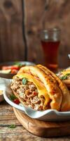 Mouth-watering sandwich filled with grilled chicken and melted cheese served with a refreshing drink at a casual dining setup photo