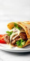 Delicious taco filled with seasoned meat, fresh vegetables, and herbs on a white plate photo