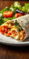 Delicious tortilla wrap filled with savory ingredients served with fresh tomatoes and greens on a white plate photo