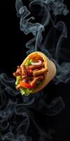 Delicious wrap filled with grilled meat, fresh vegetables, and smoke for added flavor photo
