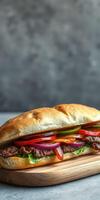 Delicious sandwich with grilled meat and fresh vegetables served on a wooden board photo