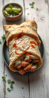 Delicious wrap filled with grilled chicken, fresh vegetables, and spicy sauce on a rustic table photo