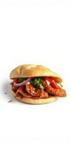Delicious chicken sandwich topped with fresh vegetables and herbs in a soft bun photo